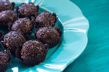 Brigadeiro. Delicious Traditional Brazilian sweet on blue plate and blue background.