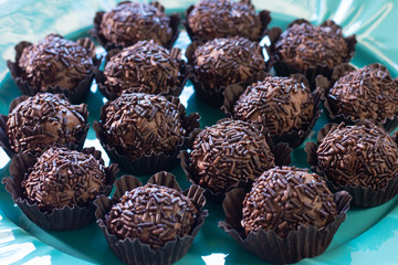 Brigadeiro. Delicious Traditional Brazilian sweet on blue plate and blue background.