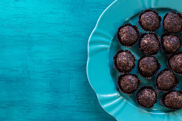 Brigadeiro. Delicious Traditional Brazilian sweet on blue plate and blue background.