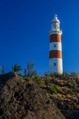 Fototapeta na wymiar The Albion lighthouse, located at Pointe aux Caves, Albion, is the only fully-operational lighthouse in Mauritius as of today