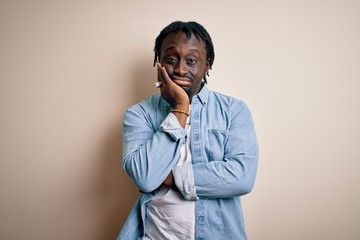 Young handsome african american man wearing casual denim shirt over white background thinking looking tired and bored with depression problems with crossed arms.