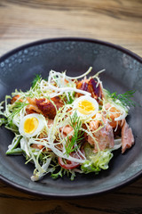 Smoked pork salad with fresh green leaves, eggs