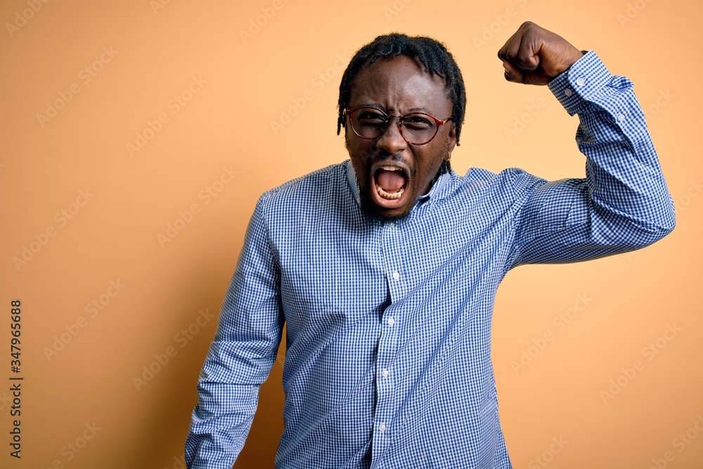 Poster young handsome african american man wearing shirt and glasses over yellow background angry and mad r