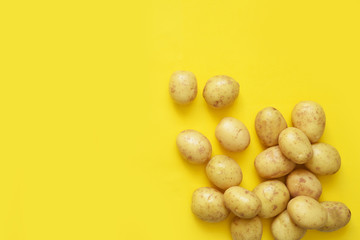 Young fresh potatoes on a yellow background.