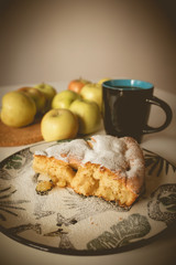 Fototapeta na wymiar Apple pie on a plate with a green pattern. A cup of tea. A cup of coffee. Apples on the table. Green apples. A feast of apples. Tea party Tasty food. White background.