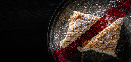 Layered cake with cream Napoleon in plate on wooden table background