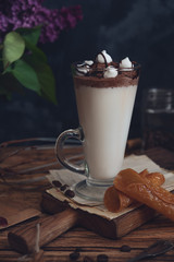 Caffe latte on dark moody background with flowers. - 347974032