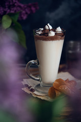 Caffe latte on dark moody background with flowers. - 347974068