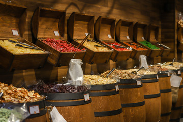 Sweets, chocolate, jelly beans of many colors inside wooden barrels in Hungary.