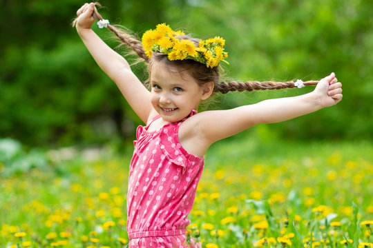Girl 5 y.o. playing in the meadow with dandelions