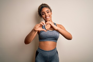 Young african american sportswoman doing sport wearing sportswear over white background smiling in...