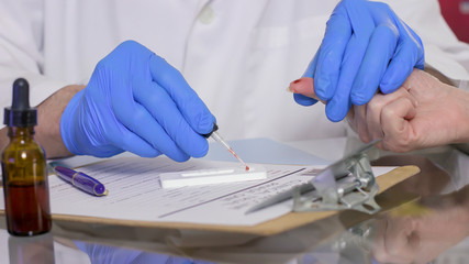 A healthcare worker or technician using a finger-stick whole blood antibody test kit to quickly...