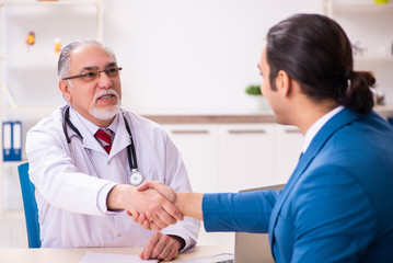 Young businessman meeting with old doctor