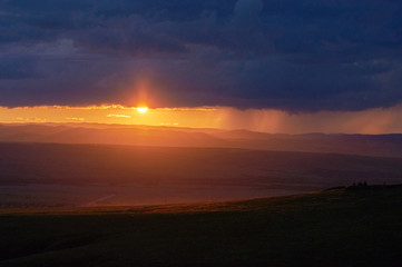 Rain over the distant hills at sunset.