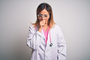 Middle age beautiful doctor woman wearing pink stethoscope over isolated white background feeling unwell and coughing as symptom for cold or bronchitis. Health care concept.