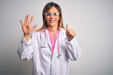 Middle age beautiful doctor woman wearing pink stethoscope over isolated white background showing and pointing up with fingers number six while smiling confident and happy.