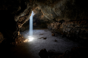 Sunlight shines from above into a small cave in the Mojave desert, California, USA