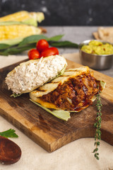 Chicken and meat arepa on a wooden board