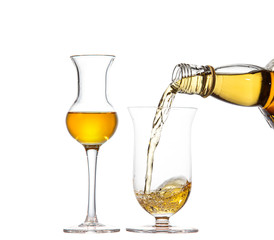 Two goblet in the shape of a tulip with whiskey. Whiskey is pouring from a bottle into a goblet.