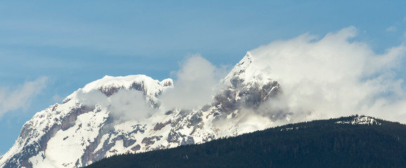 Fototapeta na wymiar Snowy mountain peaks in the wind.
