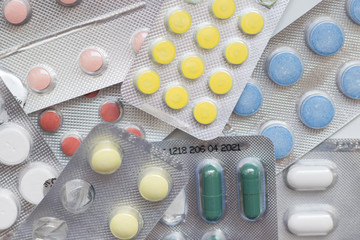 Pharmacy theme. Multicolored pills and tablets isolated on white, top view