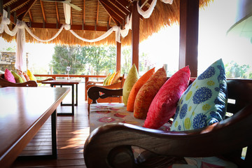 Vibrant colorful cushions in outdoor bungalow eating area restaurant at resort