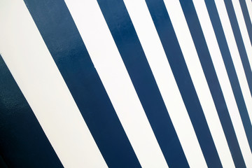 Empty surface with broad diagonal dark blue and white stripes.