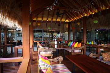 Vibrant colorful cushions in outdoor bungalow eating area restaurant at resort