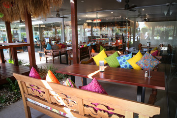 Vibrant colorful cushions in outdoor bungalow eating area restaurant at resort