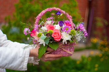 basket with flowers in the hands 