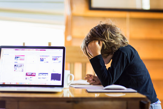 6 year old boy using laptop computer for remote schooling