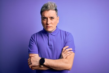 Young handsome modern man wearing casual purple t-shirt over isolated background skeptic and nervous, disapproving expression on face with crossed arms. Negative person.