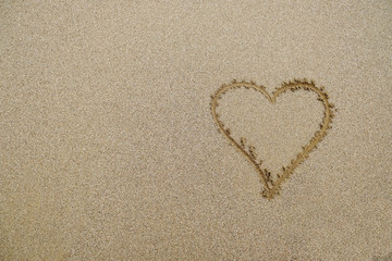 Simple heart shape drawn on sand.