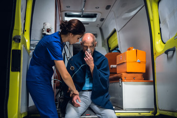 Naklejka premium A paramedic is checking the hand of a man rescued from the fire, there might be a fracture