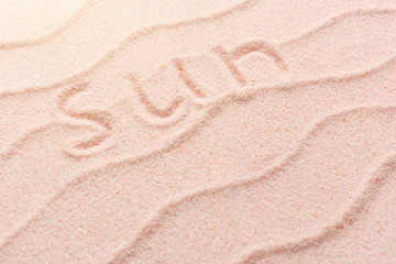 Plakat SUN lettering on sand with wave. Minimal exotic Sand, shells, vacation and travel concept, Flat lay top view copy space