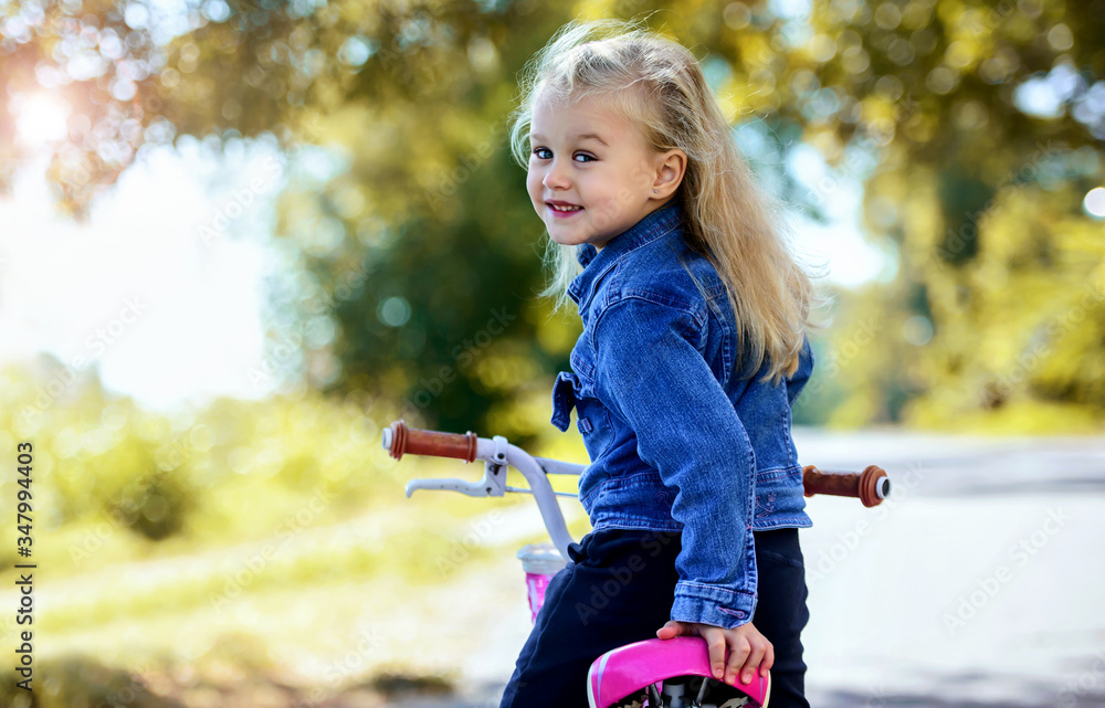 Wall mural little girl riding a bicycle