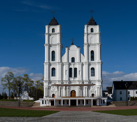 Fototapeta na wymiar Majestic Aglona Cathedral in Latvia. White Chatolic Church Basilica. Sunny Spring Day Blue Sky and White Clouds. One of the Most Important Catholic Spiritual Centers in Latvia