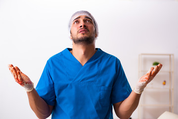 Young male doctor surgeon in fatal negligence concept