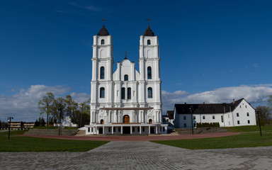 Fototapeta na wymiar Majestic Aglona Cathedral in Latvia. White Chatolic Church Basilica. Sunny Spring Day Blue Sky and White Clouds. One of the Most Important Catholic Spiritual Centers in Latvia