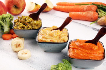 Bowls with baby food. Green, yellow and orange baby puree with fresh organic vegetables and juicy fruits