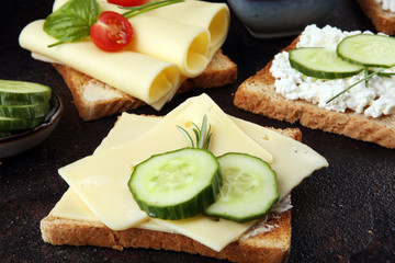 rolled slices of golden gouda cheese or cream cheese on a sandwich garnished with sliced cucumber...