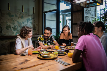 Multi-ethnic group of friends spending time in a cafe
