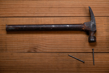 Martillo con clavos sobre una mesa de madera.