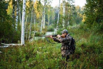Hunter aiming with weapon at the outdoor hunting