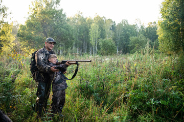 A ranger teaching his son about spotting the game in the wilderness
