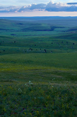 Rain clouds over distant hills at sunset.