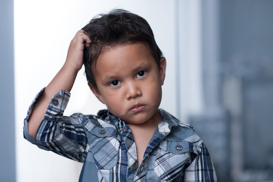 A child exibiting a mood disorder or depressed irritability, expressing sadness and pulling of his hair.
