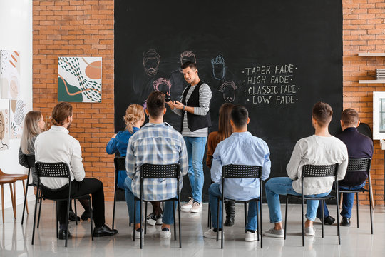 Professional hairdresser teaching young people in salon