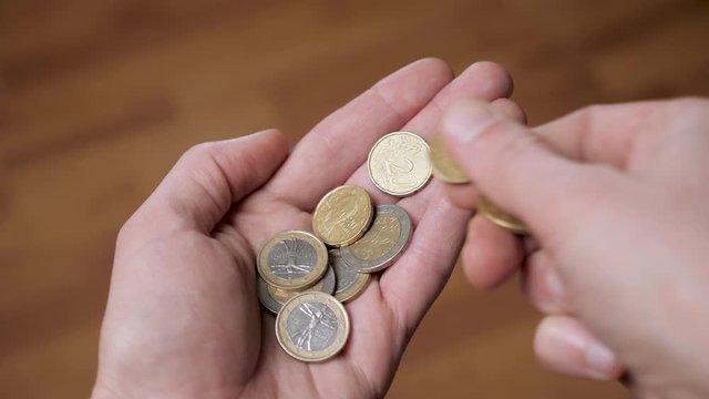 Coins in hand. Hands counting a few euro coins. A hand of coins in the palm. Economic crisis. Coins in the palm. Money in hand. Counting money, cash. Poverty concept, cash shortage. Savings. Donation