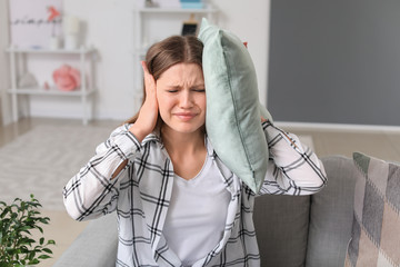 Young woman suffering from loud noise at home © Pixel-Shot